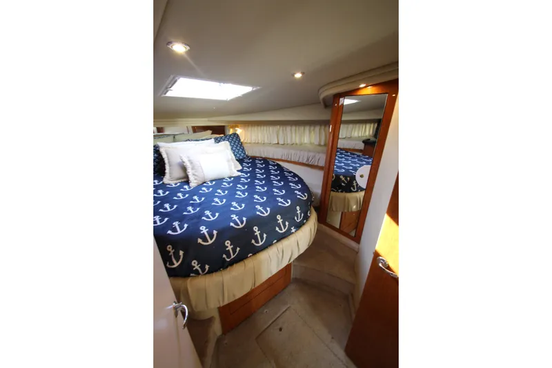 Slide: The Image of Luxurious cabin interior of 2000 Sea Ray 410 Express Cruiser with nautical-themed bedding. - 35