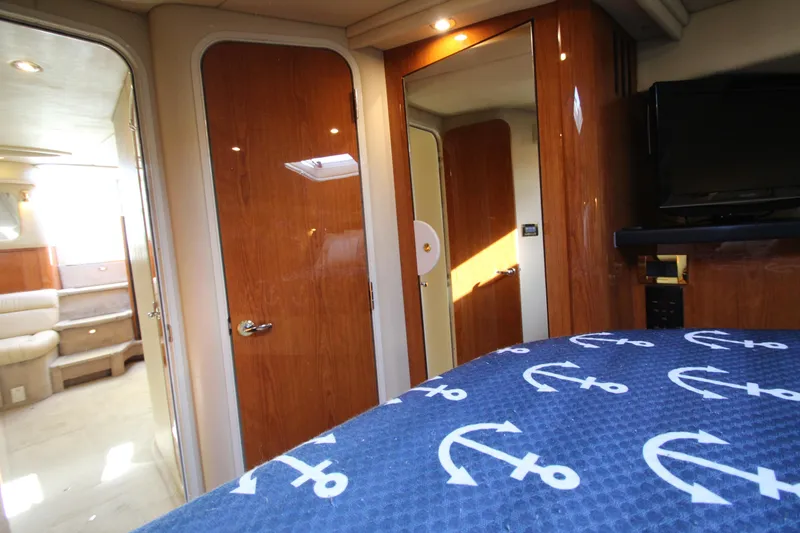 Slide: The Image of Interior of 2000 Sea Ray 410 Express Cruiser with wood finishes and nautical-themed bedding. - 37