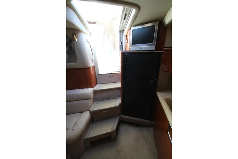 Slide: The Image of Interior of 2000 Sea Ray 410 Express Cruiser with TV, fridge, and seating area. - 40