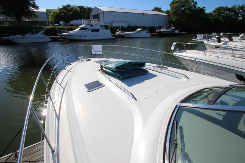 Slide: The Image of 2000 Sea Ray 410 Express Cruiser docked in a marina, surrounded by other boats. - 45