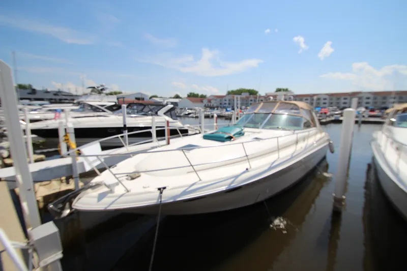 Slide: The Image of 2000 Sea Ray 410 Express Cruiser docked at marina under clear blue sky. - 2