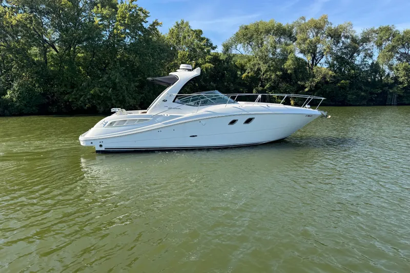 The Image of 2008 Sea Ray 350 Sundancer yacht on calm water, surrounded by lush greenery. - 0