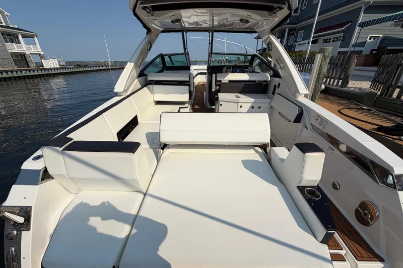 Slide: The Image of 2017 Monterey 378SE Super Express boat interior with white seating, docked by waterfront homes. - 5