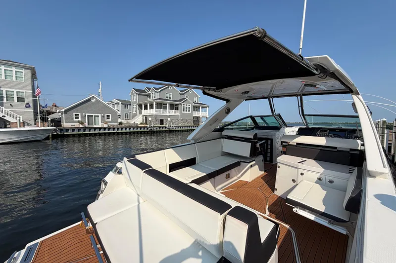 Slide: The Image of 2017 Monterey 378SE Super Express boat docked near waterfront homes under clear blue sky. - 12