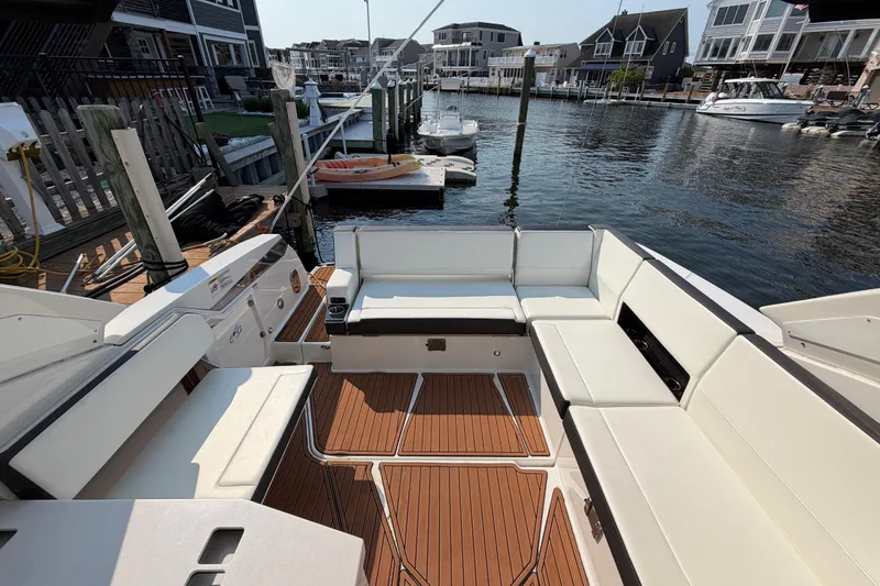Slide: The Image of 2017 Monterey 378SE Super Express boat interior with white seating and wooden deck. - 9
