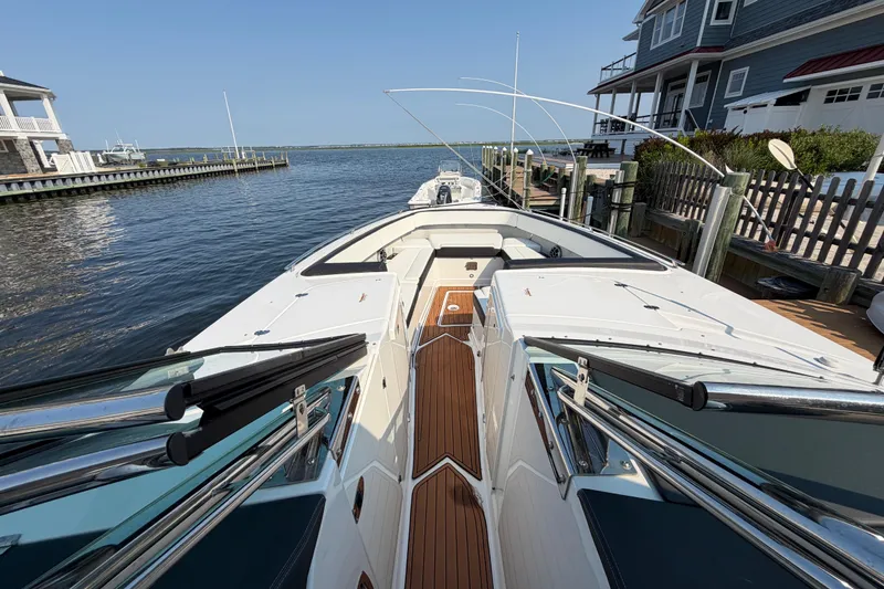 Slide: The Image of 2017 Monterey 378SE Super Express docked by waterfront homes, showcasing sleek design and spacious deck. - 24