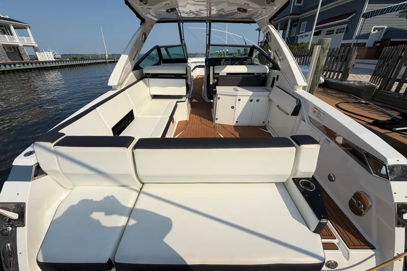 Slide: The Image of 2017 Monterey 378SE Super Express boat interior with white seating and wooden flooring. - 4