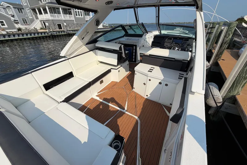 Slide: The Image of 2017 Monterey 378SE Super Express boat interior with white seating and wooden flooring. - 6