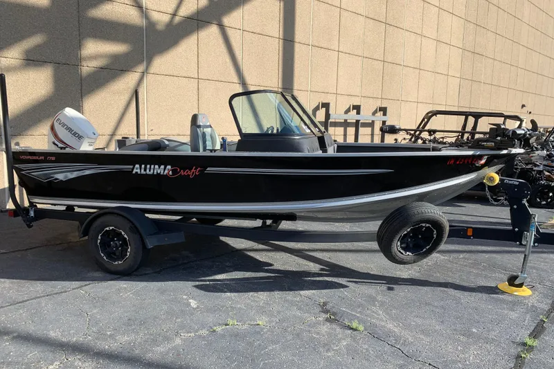 The Image of 1993 Alumacraft Trophy 175 boat on trailer, parked outdoors, featuring Evinrude motor. - 1