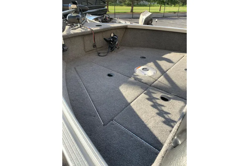Slide: The Image of 1993 Alumacraft Trophy 175 boat interior with carpeted deck and fishing equipment. - 2