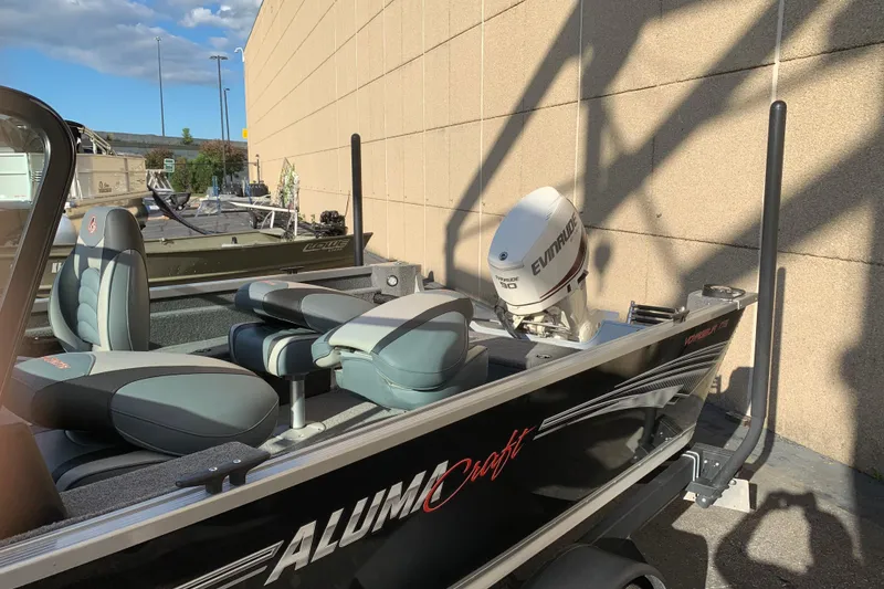 Slide: The Image of 1993 Alumacraft Trophy 175 boat with Evinrude motor, parked outdoors in sunlight. - 5