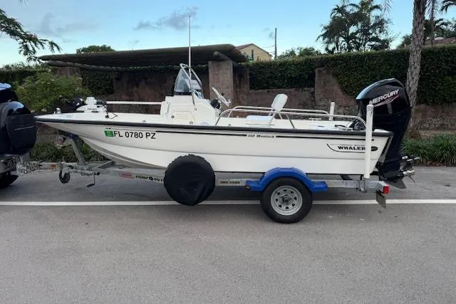 The Image of 2016 Boston Whaler 150 Montauk boat on trailer, parked outdoors. - 0