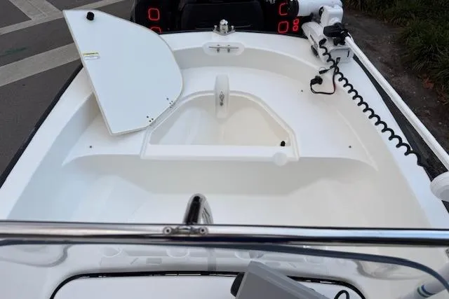 Slide: The Image of 2016 Boston Whaler 150 Montauk boat interior with open storage compartment and trolling motor. - 17