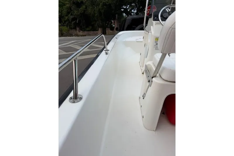 Slide: The Image of 2016 Boston Whaler 150 Montauk boat interior with white seating and stainless steel railing. - 19