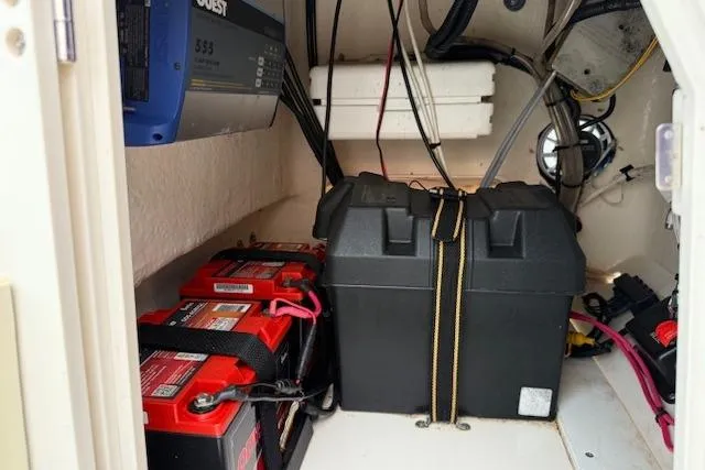 Slide: The Image of 2016 Boston Whaler 150 Montauk boat battery compartment with secured batteries and wiring. - 26