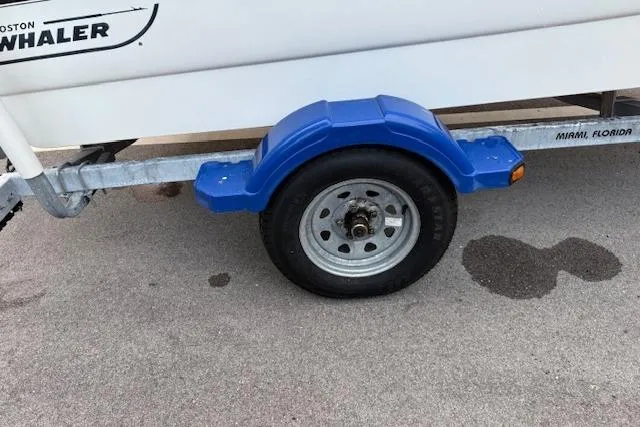 Slide: The Image of Trailer wheel of a 2016 Boston Whaler 150 Montauk, parked on pavement. - 32