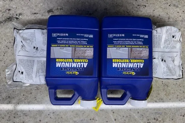 Slide: The Image of Two blue bottles of aluminum cleaner and restorer on a concrete surface. - 35