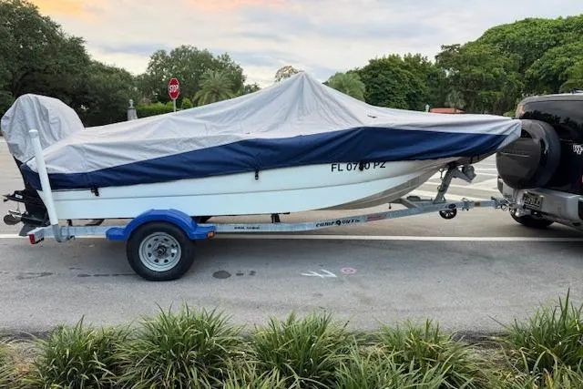 Slide: The Image of Covered 2016 Boston Whaler 150 Montauk on trailer, parked beside a vehicle. - 4
