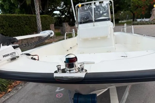 Slide: The Image of 2016 Boston Whaler 150 Montauk boat with Minn Kota trolling motor, parked on a trailer. - 6