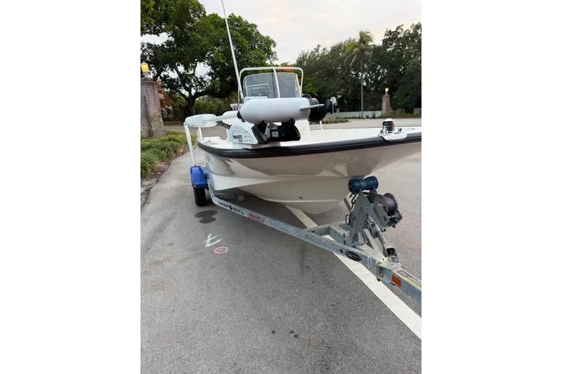 Slide: The Image of 2016 Boston Whaler 150 Montauk boat on trailer, parked on a street. - 7