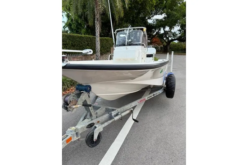 Slide: The Image of 2016 Boston Whaler 150 Montauk boat on trailer, parked on a road. - 8