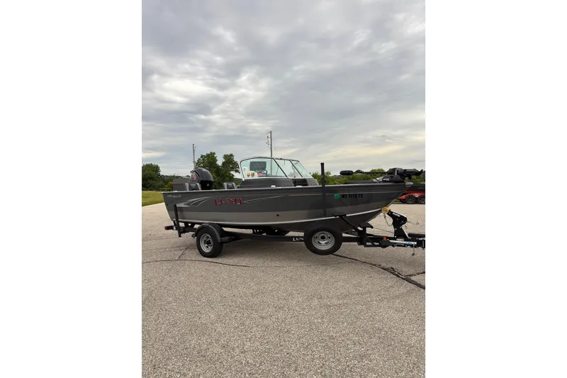 Slide: The Image of 2018 Lund 1775 Impact XS boat on trailer under cloudy sky. - 2