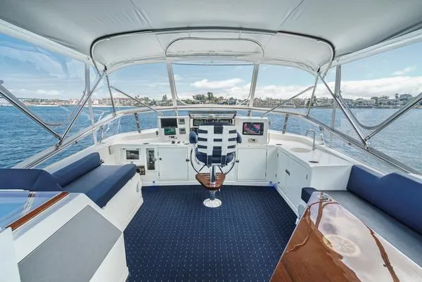 Slide: The Image of The image shows a yacht's helm with blue seating and a central steering wheel. - 12