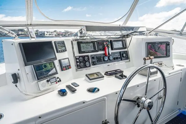Slide: The Image of Yacht helm with multiple screens and a steering wheel. - 16