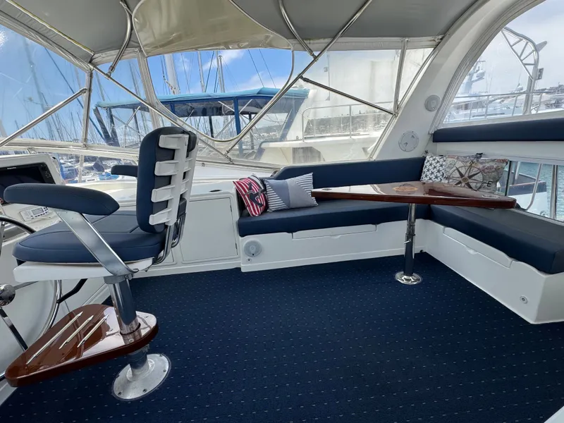 Slide: The Image of Interior of a 2002 Jefferson Rivanna 50 Sundeck MY with blue upholstery and a wooden table. - 23