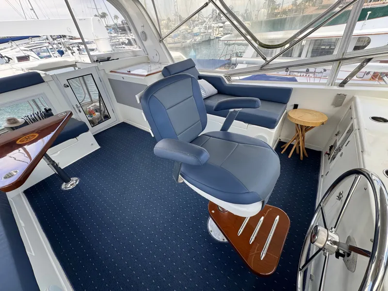 Slide: The Image of Interior of a 2002 Jefferson Rivanna 50 Sundeck MY with blue seating and a steering wheel. - 26