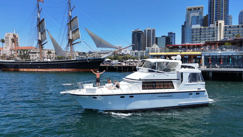 Slide: The Image of A white motor yacht cruises in a harbor with modern buildings in the background. - 3