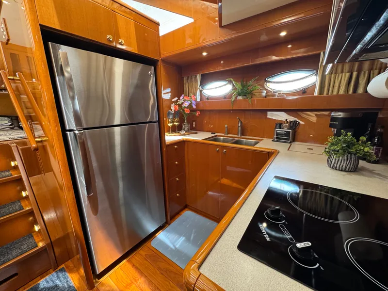 Slide: The Image of The 2002 Jefferson Rivanna 50 Sundeck MY kitchen features a stainless steel fridge and modern cooktop. - 37