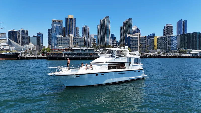 Slide: The Image of A white yacht cruises on calm waters with a skyline of modern skyscrapers in the background. - 4
