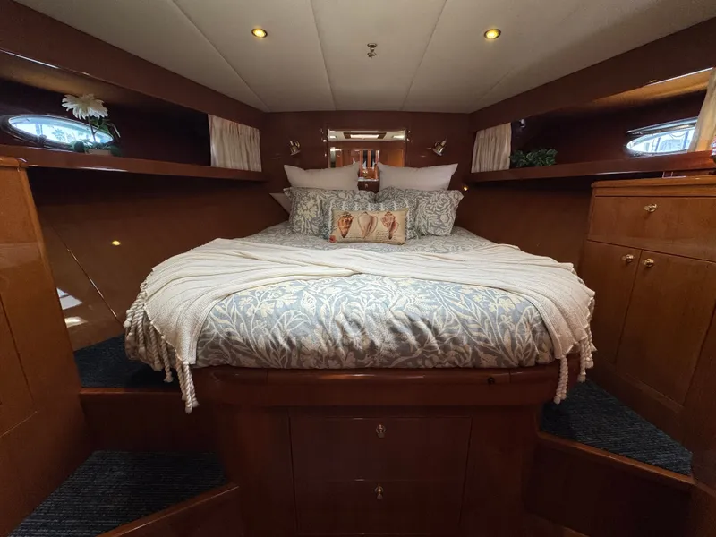 Slide: The Image of Luxurious bedroom with a large bed, wooden cabinetry, and plush pillows on a yacht. - 42