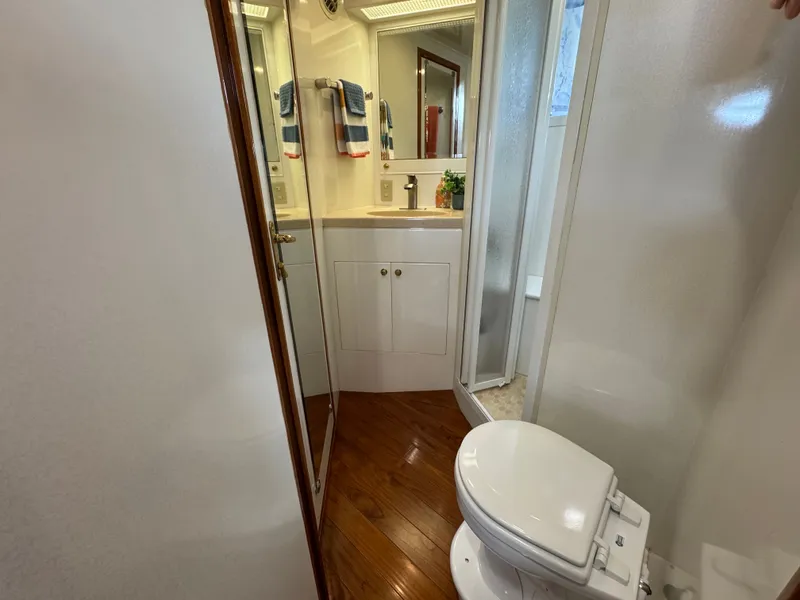 Slide: The Image of Bathroom on a boat with toilet, sink, and shower. Features wood flooring and a mirror. - 45