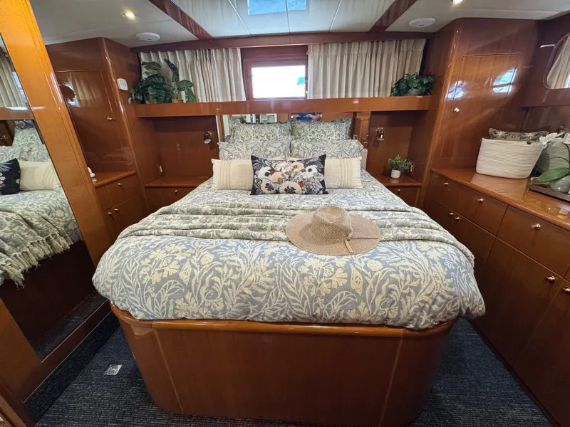 Slide: The Image of The image shows a cozy yacht bedroom with a large bed and elegant wood paneling. - 46