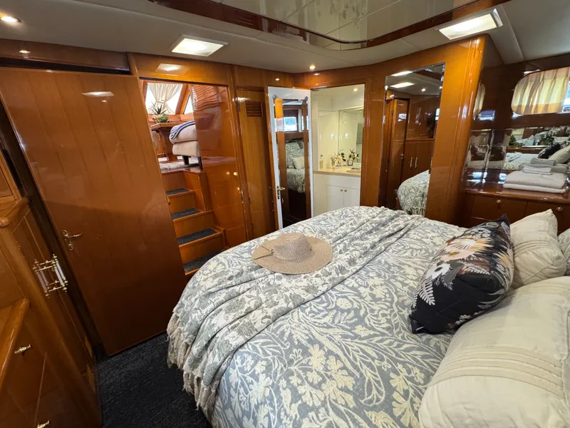 Slide: The Image of Interior of a luxurious cabin with a large bed, wooden furnishings, and a bathroom. - 47