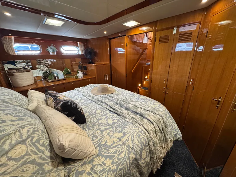Slide: The Image of Luxurious bedroom with wooden furnishings and a large bed, adorned with pillows and blankets. - 48