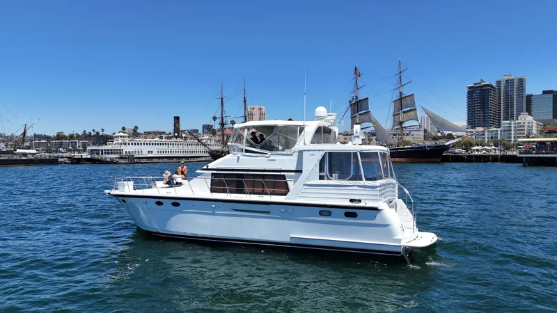 Slide: The Image of A white motor yacht on calm water, surrounded by other ships and a cityscape. - 6