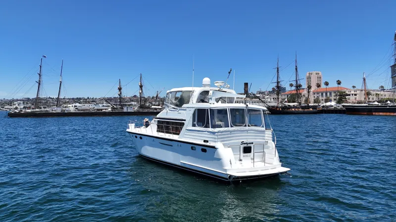 Slide: The Image of A white motor yacht on the water with several masts in the background. - 7