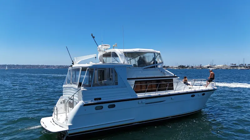 Slide: The Image of A white motor yacht cruises on calm water under a clear sky. - 8