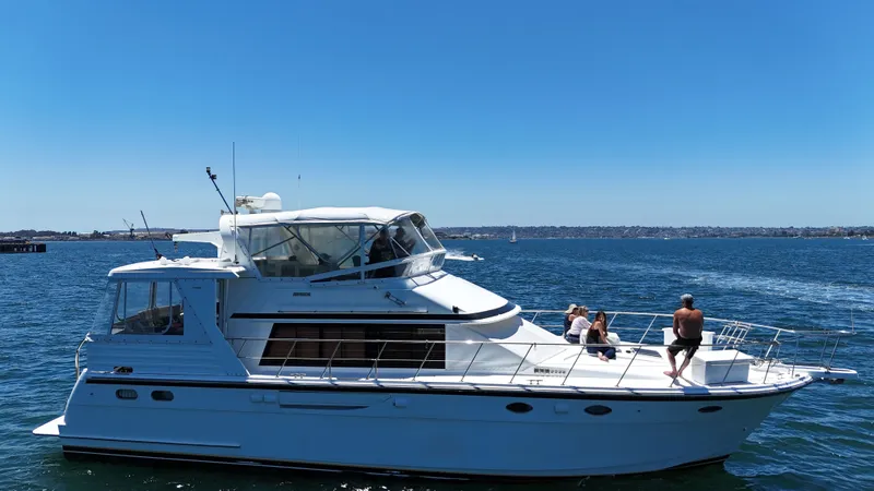 Slide: The Image of A white motor yacht cruises on calm water under a clear sky. - 9
