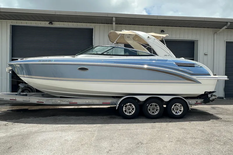 The Image of 2018 Formula 290 Bowrider boat on trailer, parked outside a garage. - 0