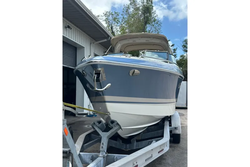 Slide: The Image of 2018 Formula 290 Bowrider boat on trailer, parked near a building, under a clear sky. - 3