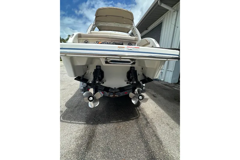 Slide: The Image of 2018 Formula 290 Bowrider boat rear view with dual propellers, parked outdoors. - 5