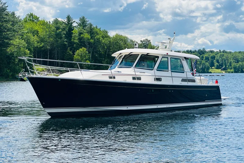 Slide: The Image of 2025 Sabre 48 Salon Express yacht cruising on a scenic lake. - 1