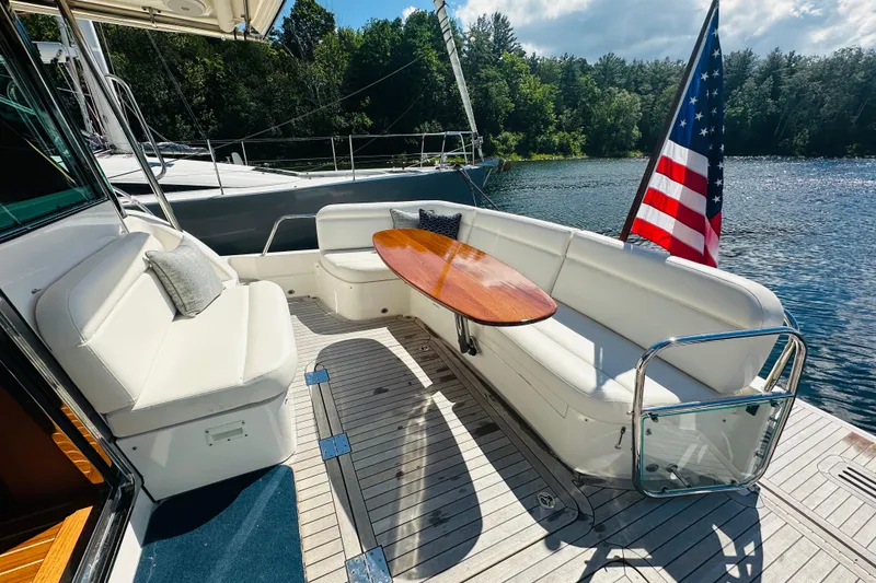 Slide: The Image of Luxurious 2025 Sabre 48 Salon Express yacht deck with seating and American flag. - 10