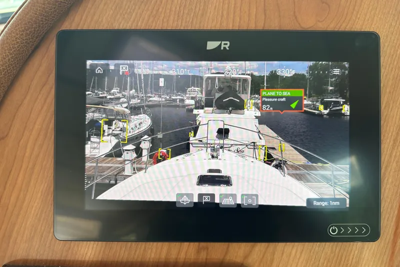 Slide: The Image of 2025 Sabre 48 Salon Express navigation display showing marina with boats and distance indicators. - 101