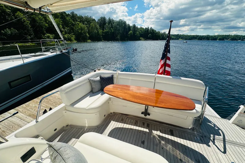 Slide: The Image of 2025 Sabre 48 Salon Express yacht with elegant seating and scenic lake view. - 11