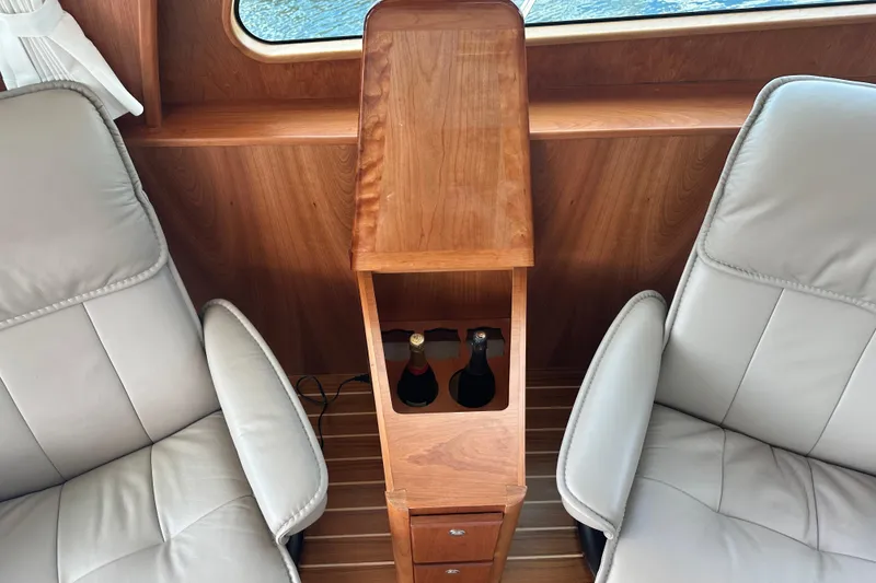 Slide: The Image of Interior of 2025 Sabre 48 Salon Express with leather seats and wooden bottle holder. - 17